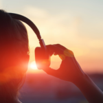 Person listening to music at sunset